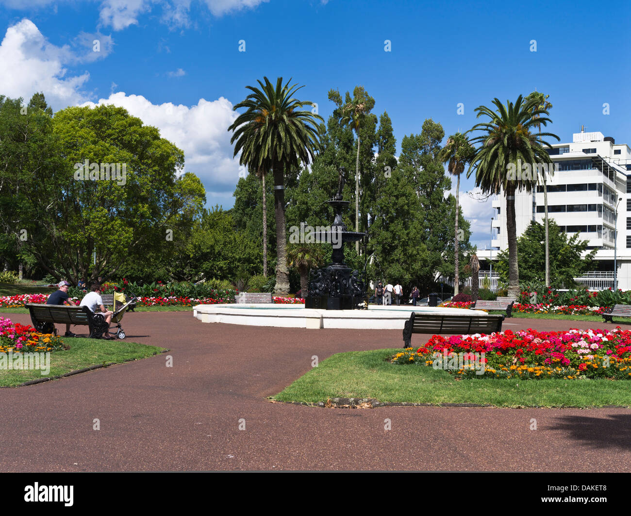 dh Albert Park AUCKLAND NEW ZEALAND People sitting bench relaxing fountain pool flower garden city parks Stock Photo