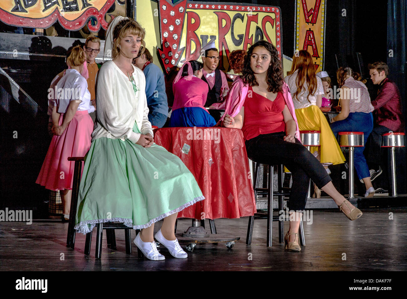 In 1950's clothing, Sandy Dumbrowski (left) and Rizzo talk at Rydell High School in a student production of the musical 'Grease' Stock Photo