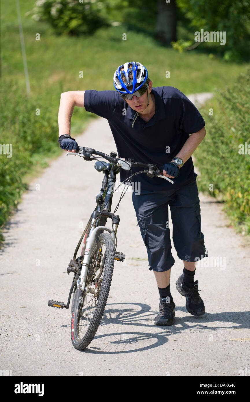 Cyclist walking with bicycle Stock Photo