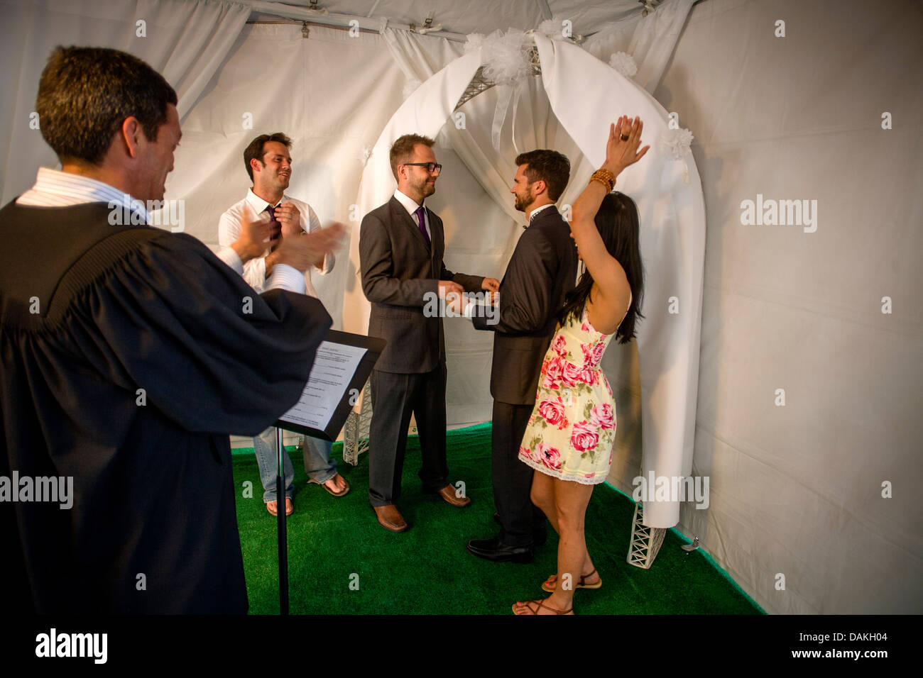 A Deputy Commissioner of Civil Marriages in West Hollywood, CA, officiates at a civil marriage ceremony for a gay male couple. Stock Photo