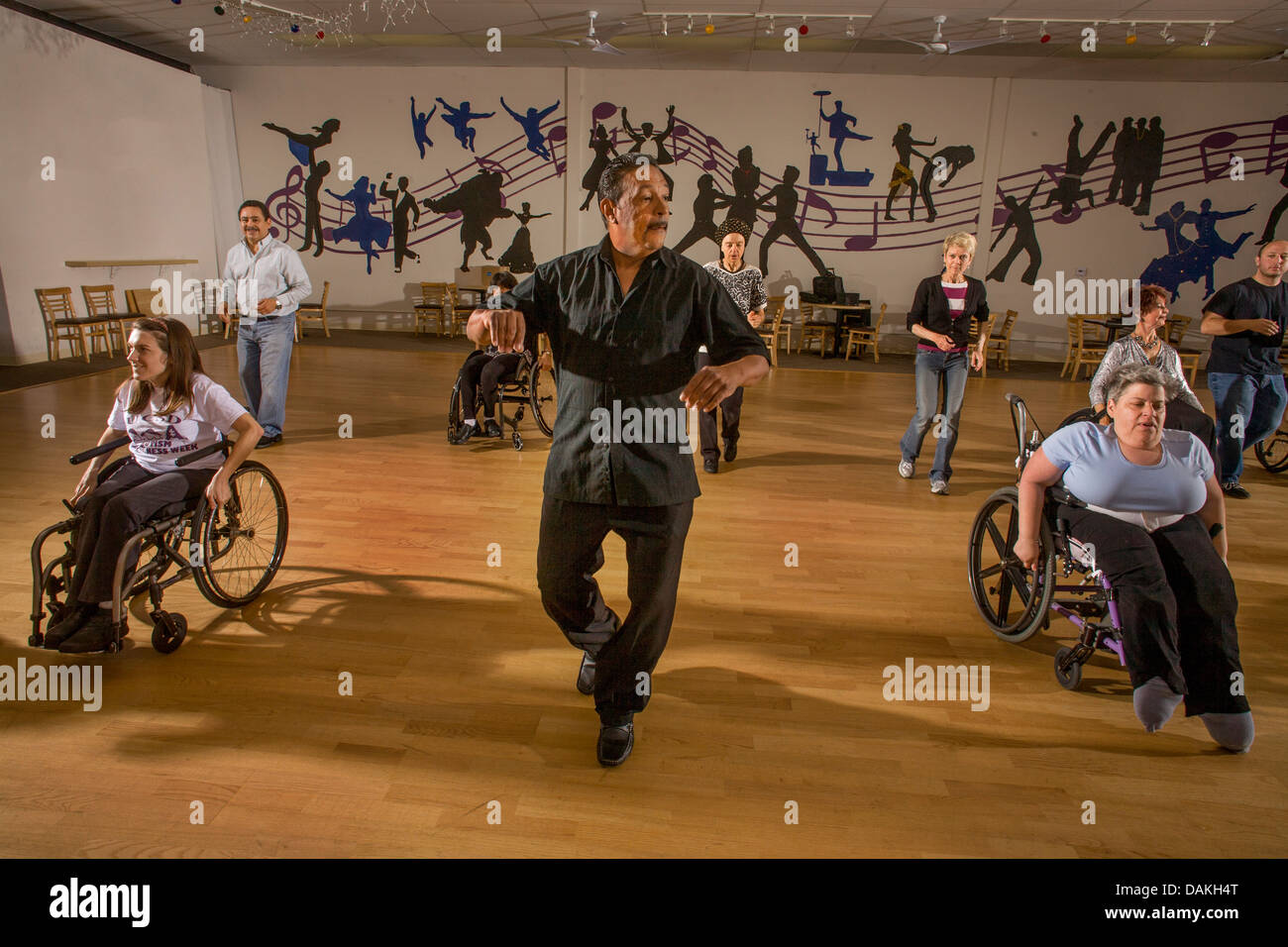 An African American dance teacher instructs handicapped adults in wheelchair dancing with normal adults in San Diego, CA, Stock Photo