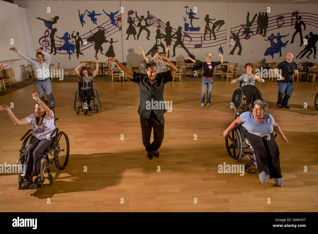 An African American dance teacher instructs handicapped adults in wheelchair dancing with normal adults in San Diego, CA. Stock Photo
