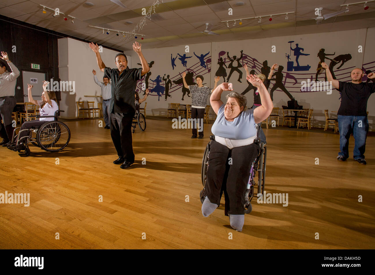 An African American dance teacher instructs handicapped adults in wheelchair dancing with normal adults in San Diego, CA, Stock Photo