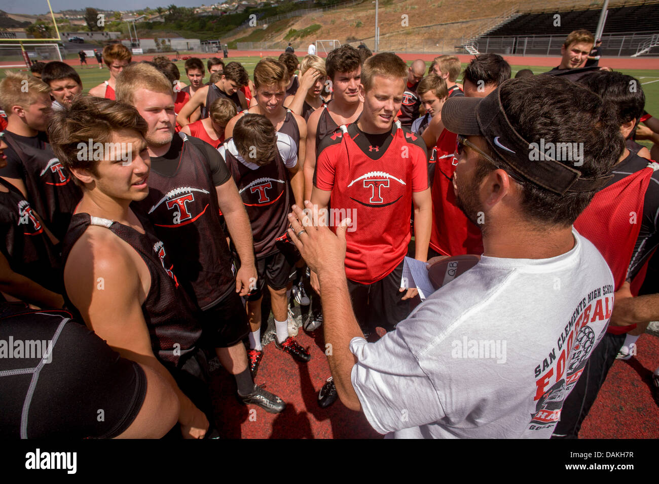 A high school coach gives a pep talk to his new team during spring football practice in San Clemente, CA. Stock Photo