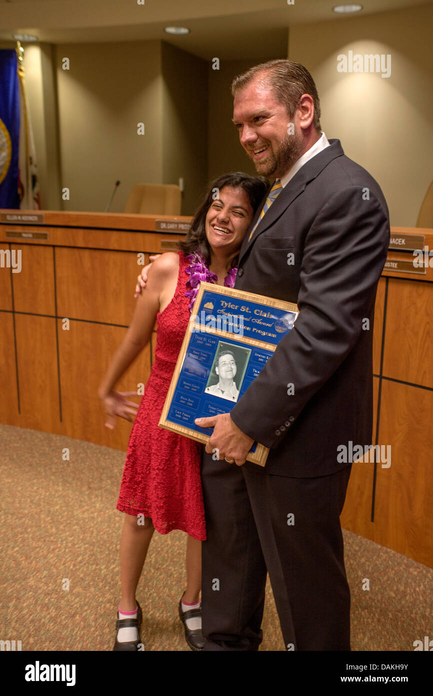 A happy graduate receives her diploma at her Adult Transition Program (ATP) graduation in San Juan Capistrano, CA. Stock Photo