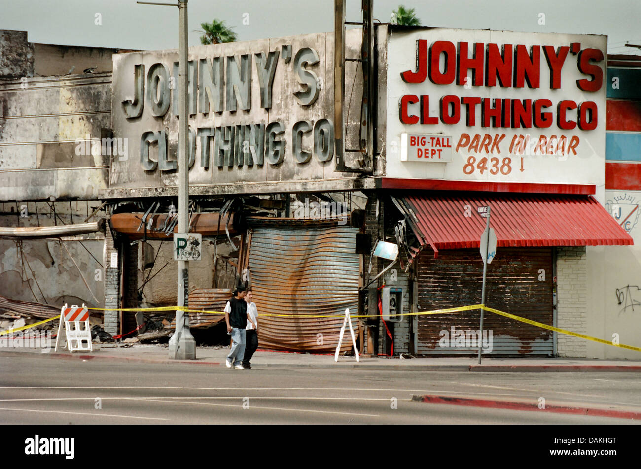 Hispanic youths pass fire damaged shops in South Central Los Angeles after the 1992 Rodney King race riot in Los Angeles. Stock Photo