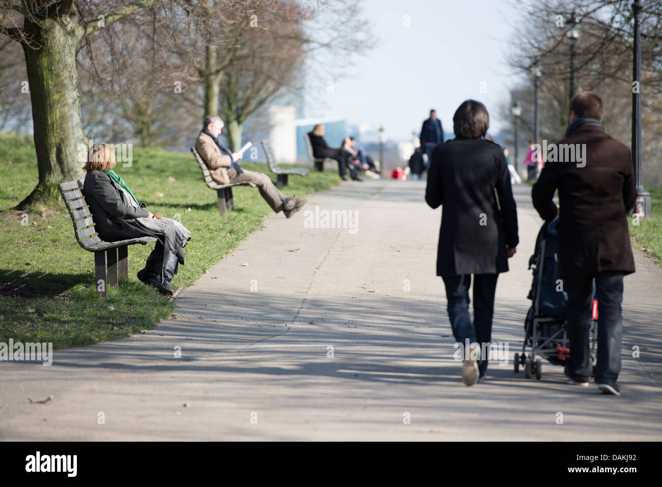 People relaxing on park benches on Primrose Hill, London Stock Photo