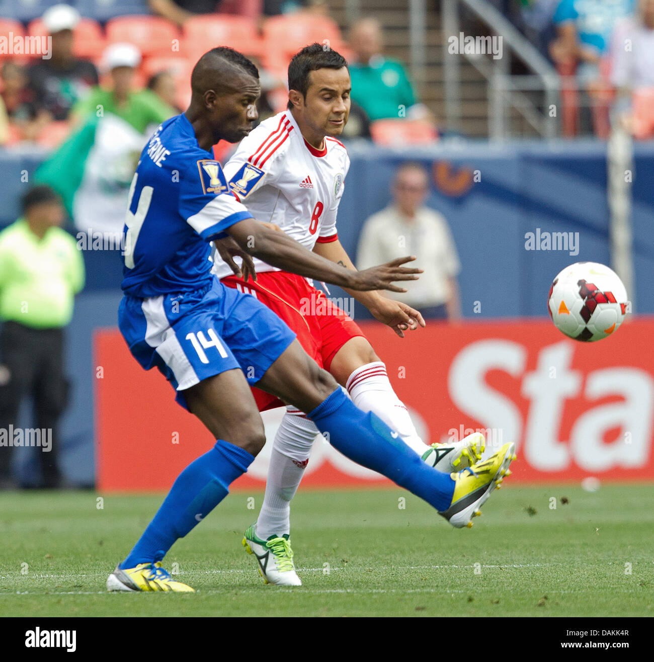 July 14, 2013 - Denver, Colorado, U.S - Mexico's LUIS MONTES, right, battles for the ball with Martinique's FABRICE REUPERNE, left, during the 2nd. half at Sports Authority Field at Mile High Sunday afternoon. Mexico defeats Martinique 3-1. (Credit Image: © Hector Acevedo/ZUMAPRESS.com) Stock Photo