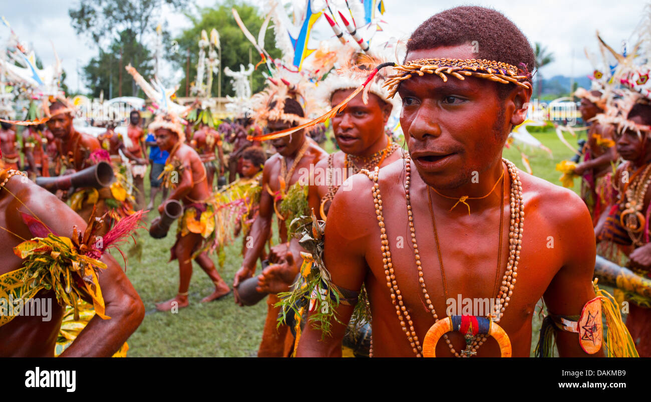 Man with his body painted red and dancing in a group at the Goroka Show in Papue New Guinea Stock Photo