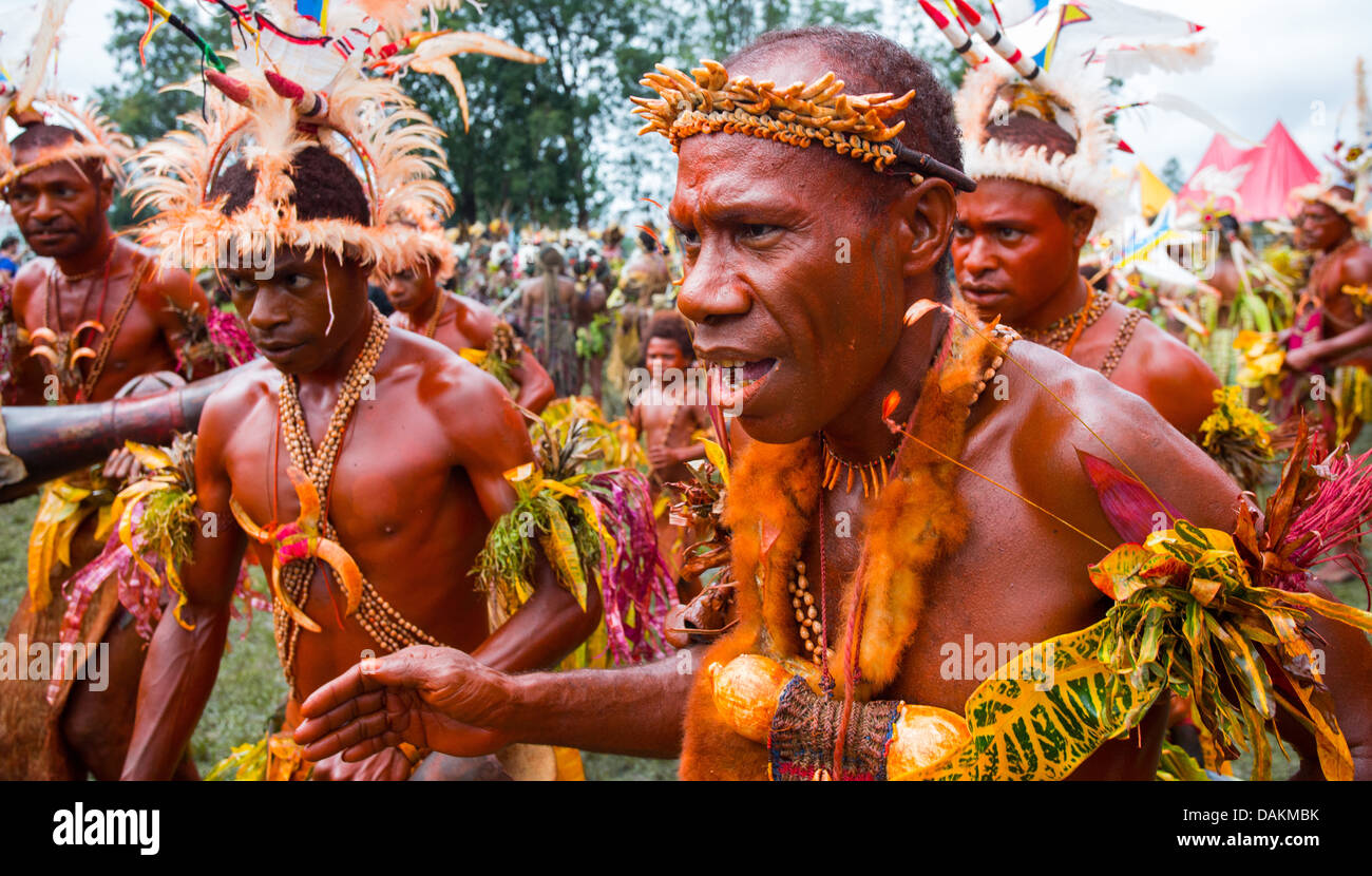 Man with his body painted red and dancing in a group at the Goroka Show in Papue New Guinea Stock Photo