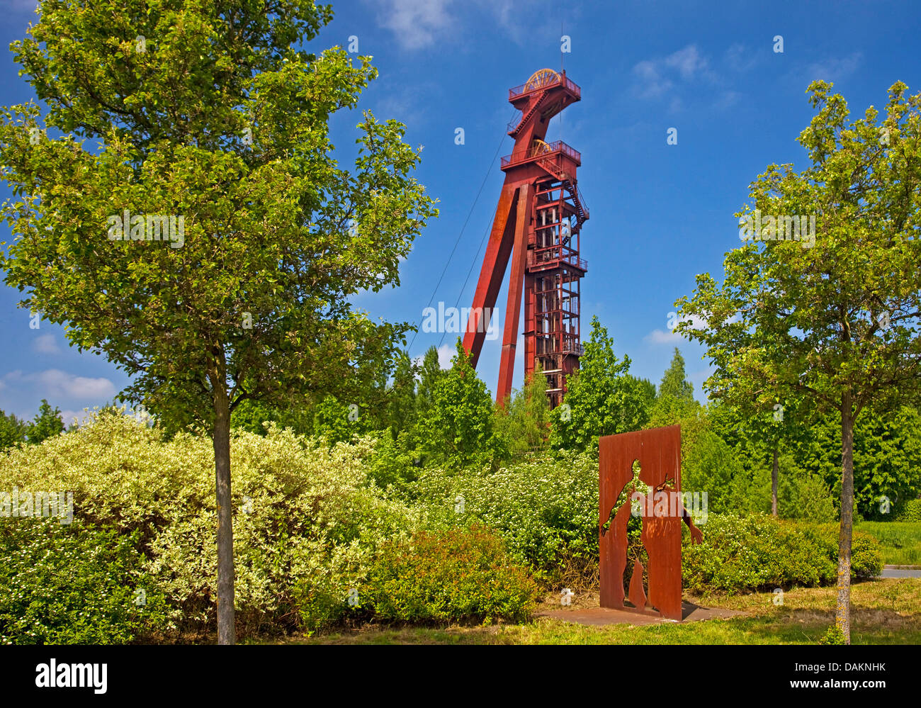 shaft tower of the shaft Grillo of the shut-down coal mine Monopol with the artwork called 'Strukturwandel' (structural transformation') in the foreground, Germany, North Rhine-Westphalia, Ruhr Area, Kamen Stock Photo