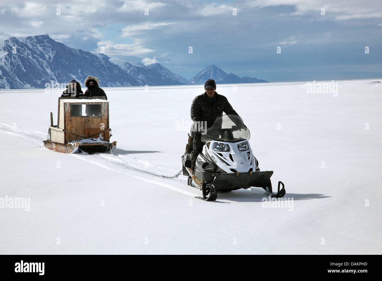three persons with sleds in arctic landscape, Canada, Nunavut Stock Photo