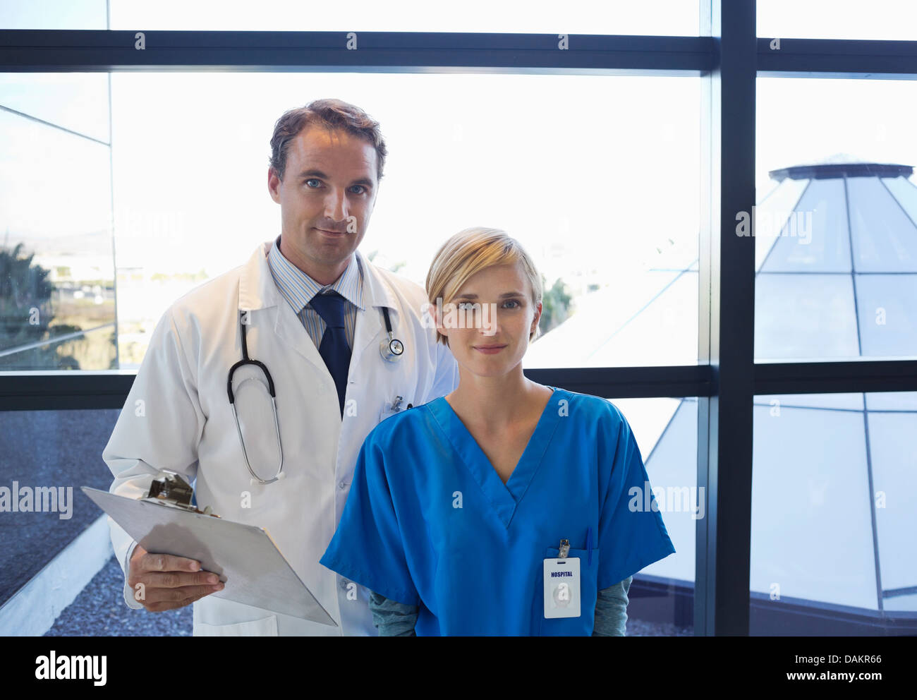 Doctor and nurse standing by window Stock Photo