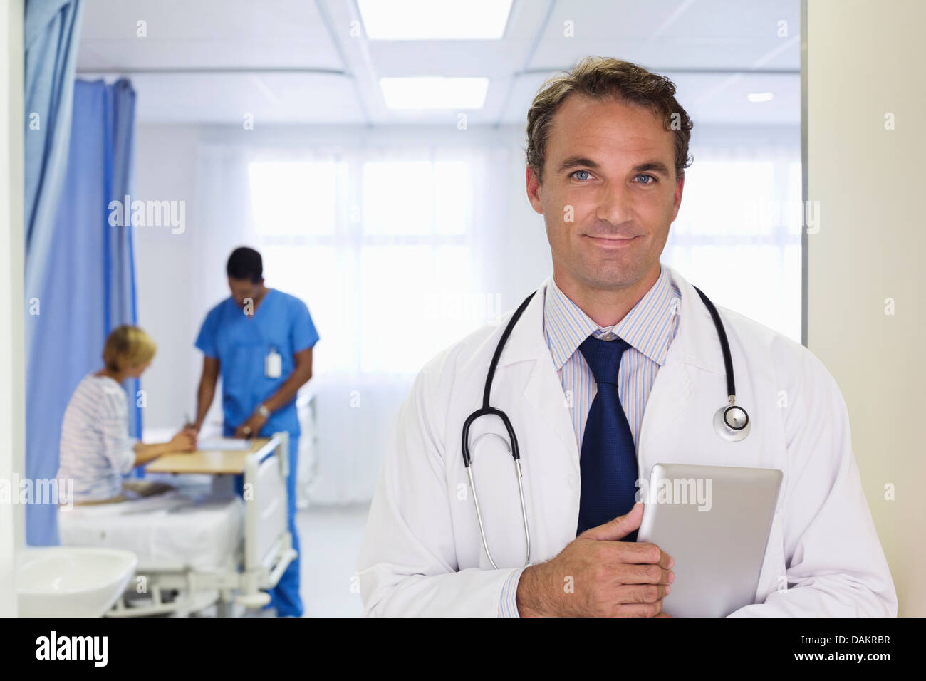 Doctor carrying tablet computer in hospital Stock Photo