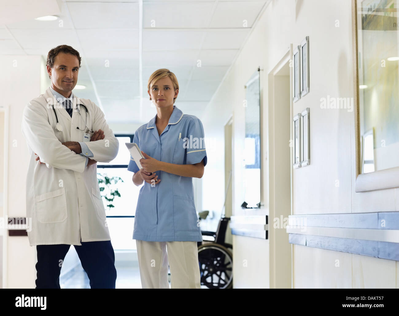 Doctor and nurse standing in hospital hallway Stock Photo