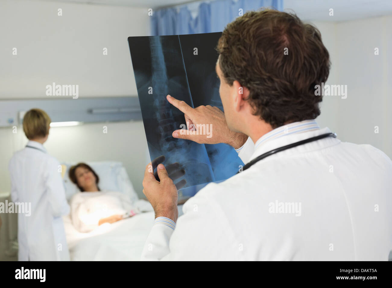 Doctor examining x-rays in hospital room Stock Photo