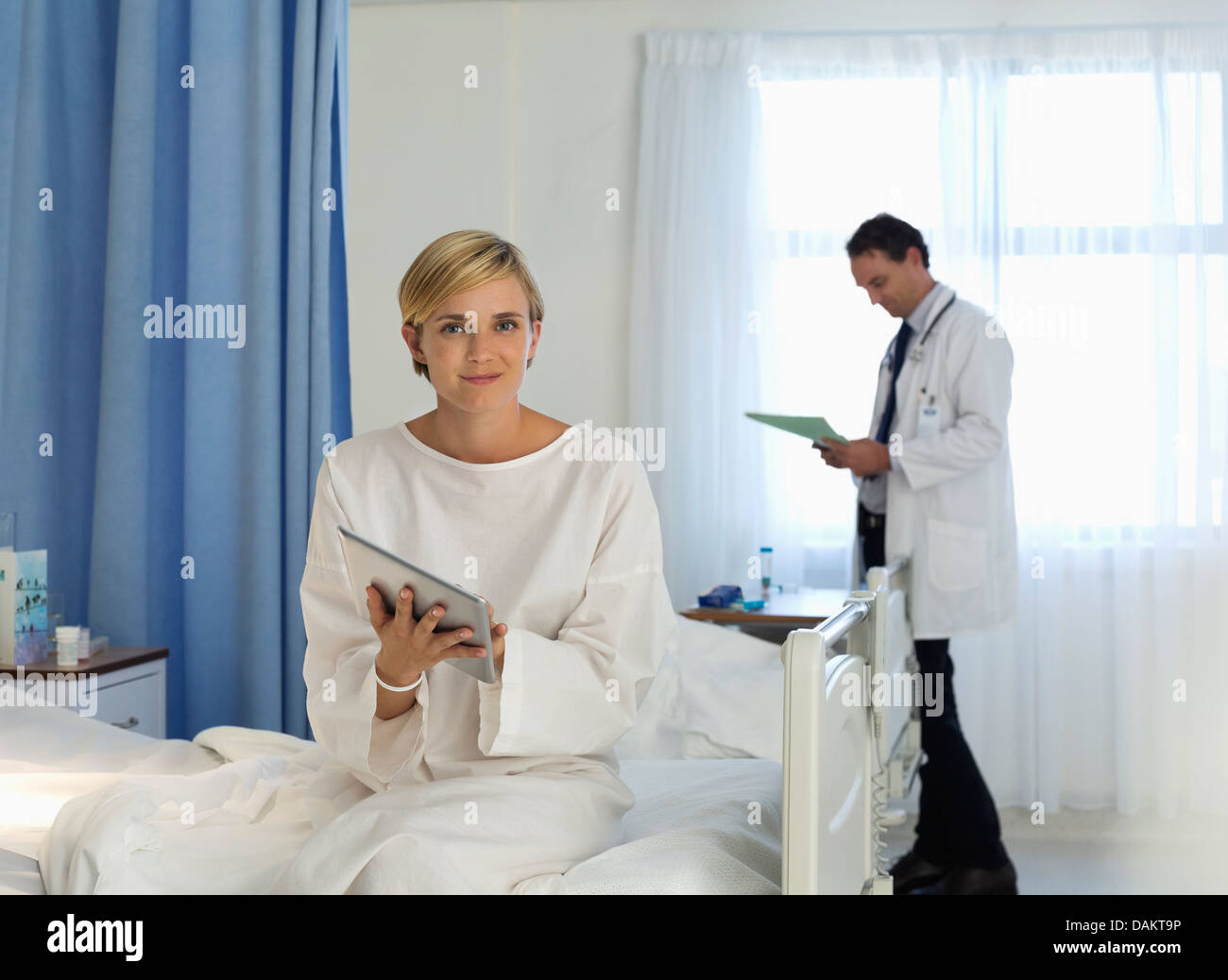 Patient using tablet computer in hospital room Stock Photo