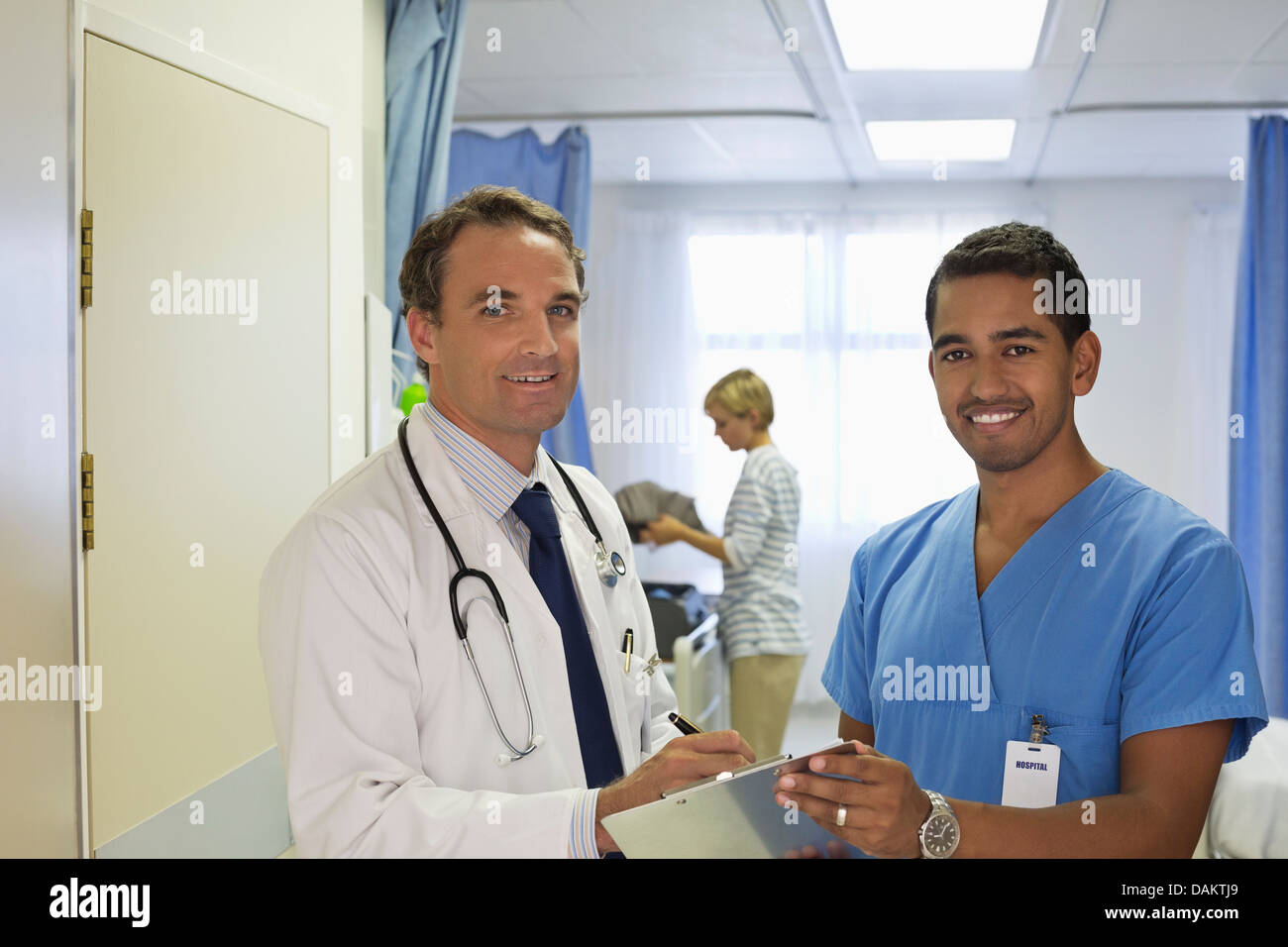Doctor and nurse talking in hospital room Stock Photo