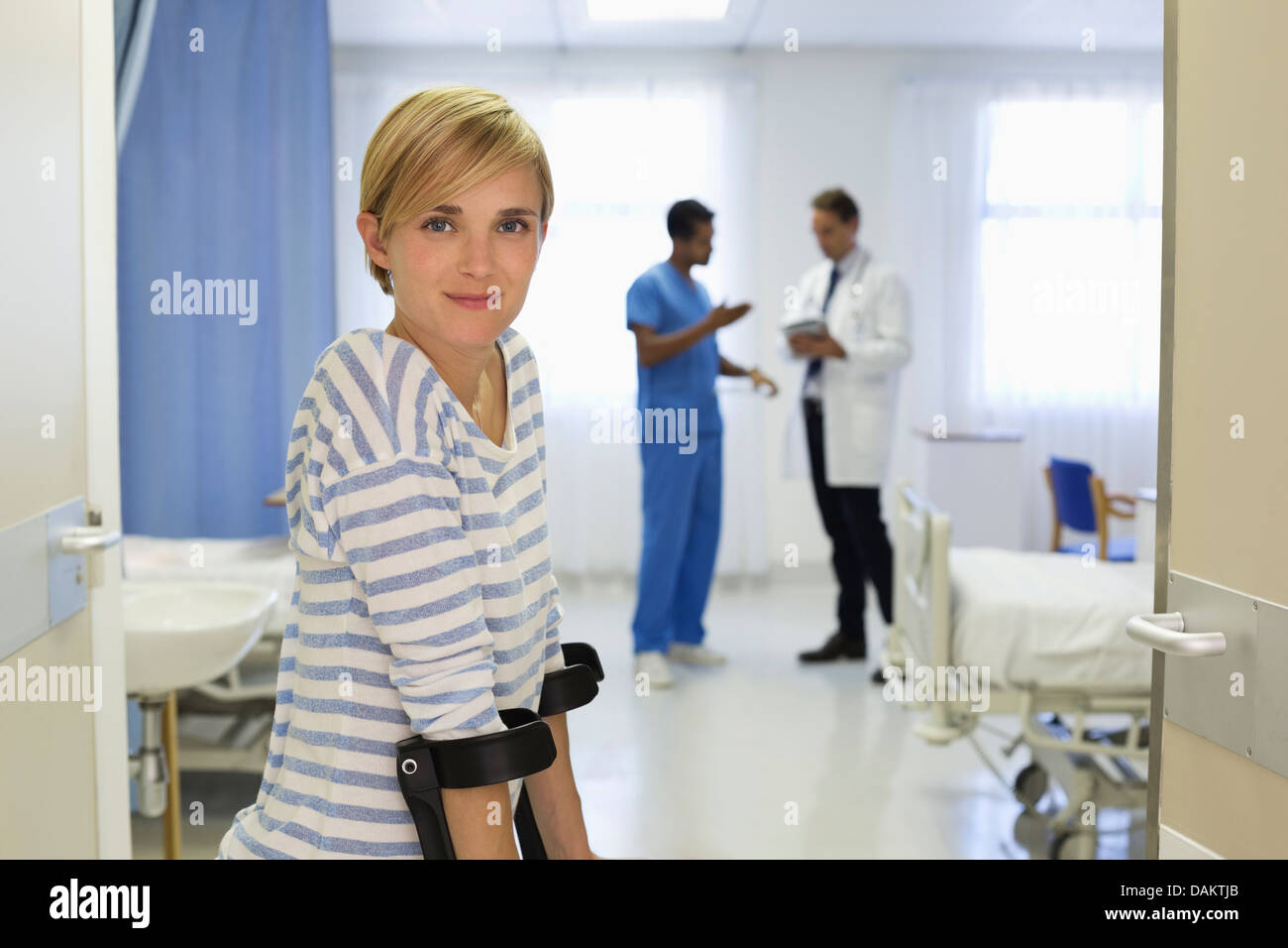 Patient using crutches in hospital room Stock Photo