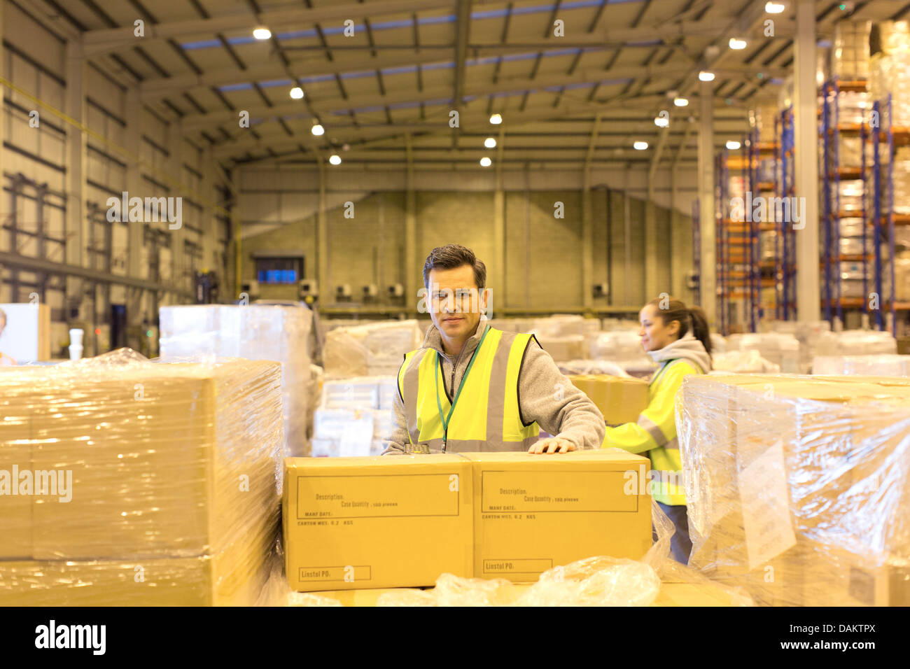 Worker unpacking boxes in warehouse Stock Photo - Alamy