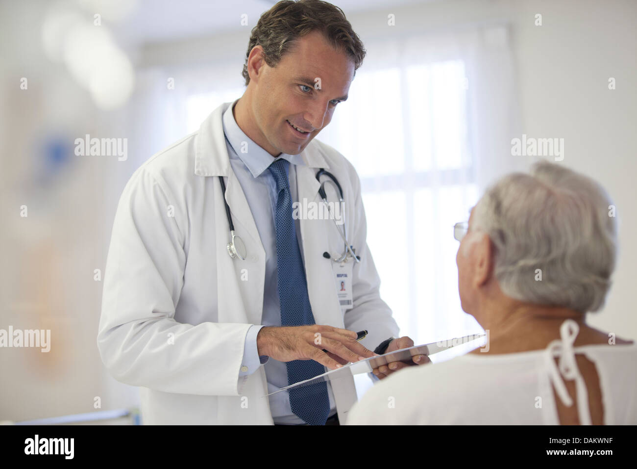 Doctor talking to older patient in hospital Stock Photo