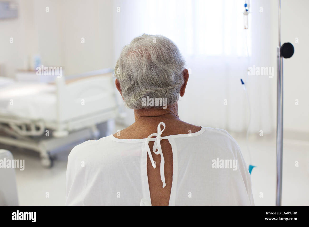 Older patient wearing gown in hospital room Stock Photo Alamy