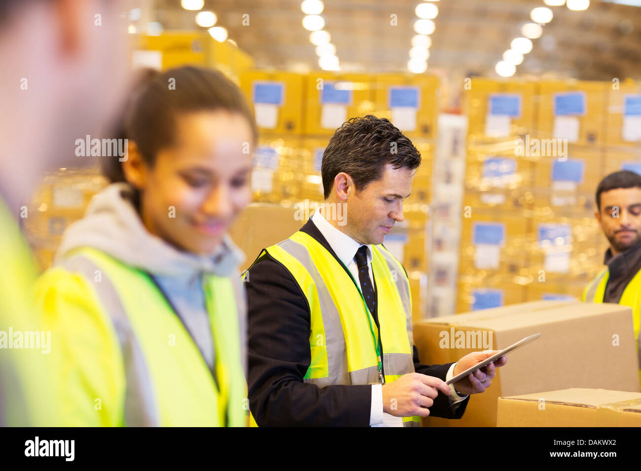 Businessman and workers in warehouse Stock Photo