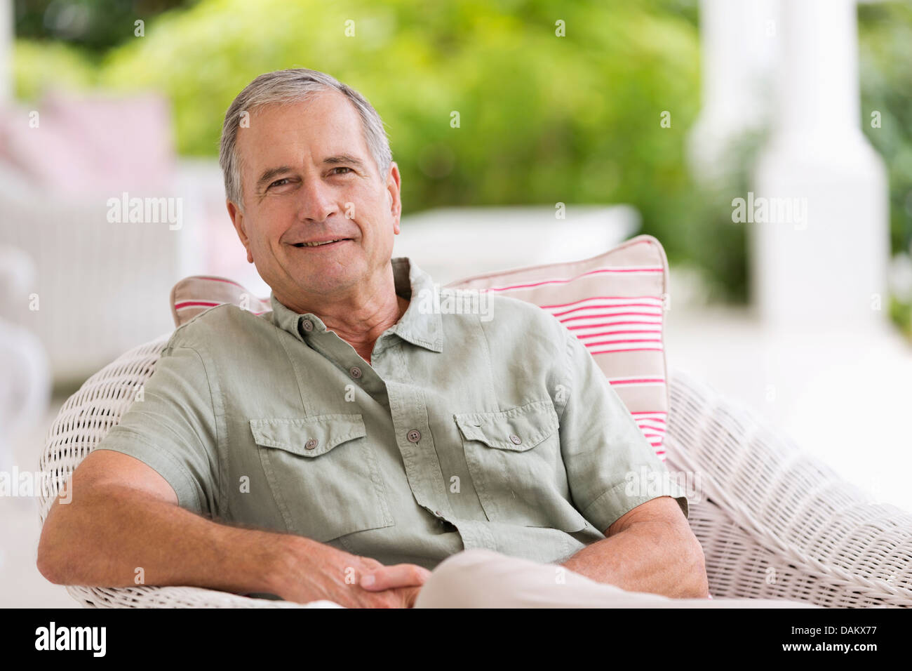 Older man sitting in armchair outdoors Stock Photo