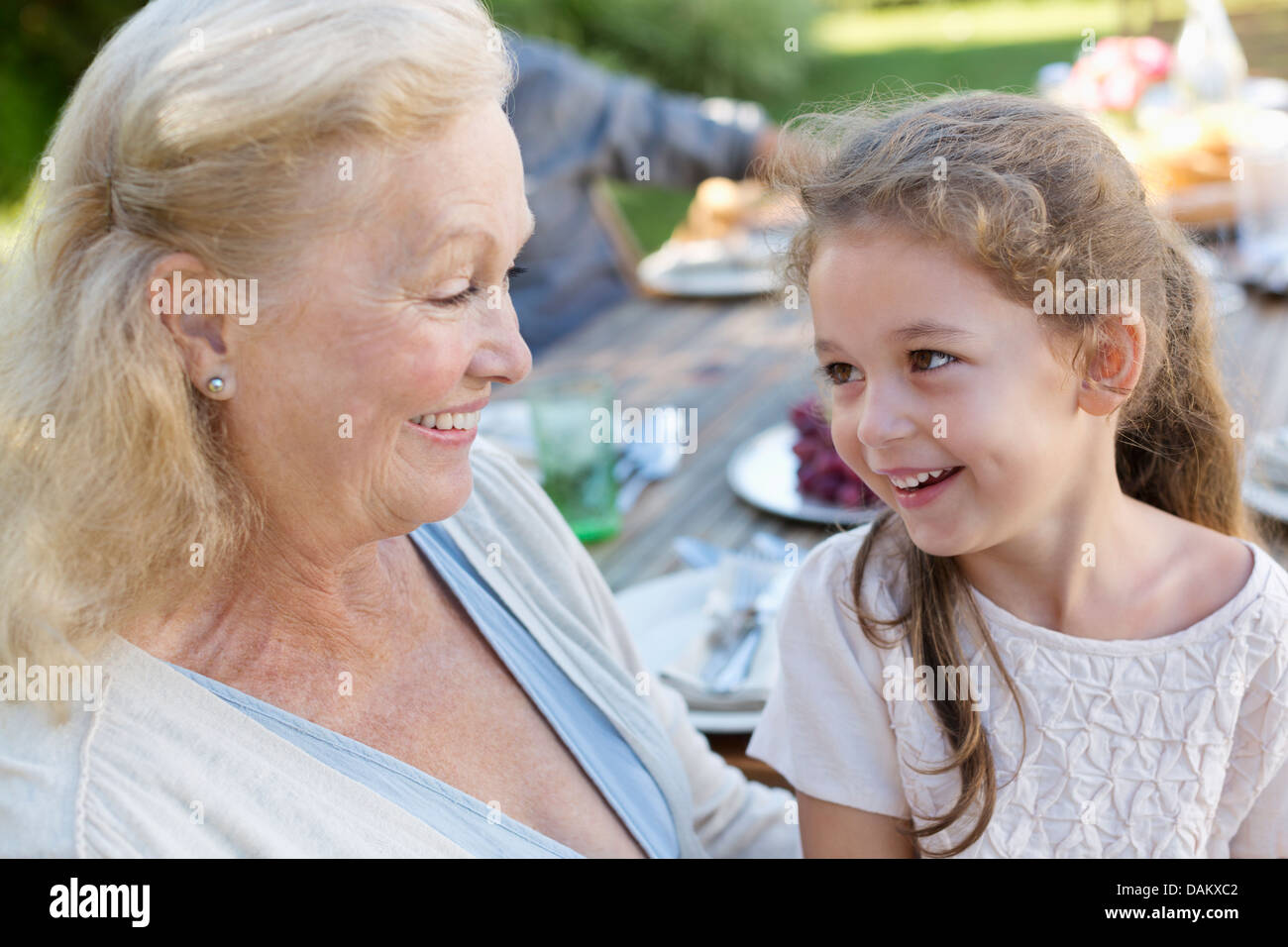 Older woman sitting with granddaughter outdoors Stock Photo