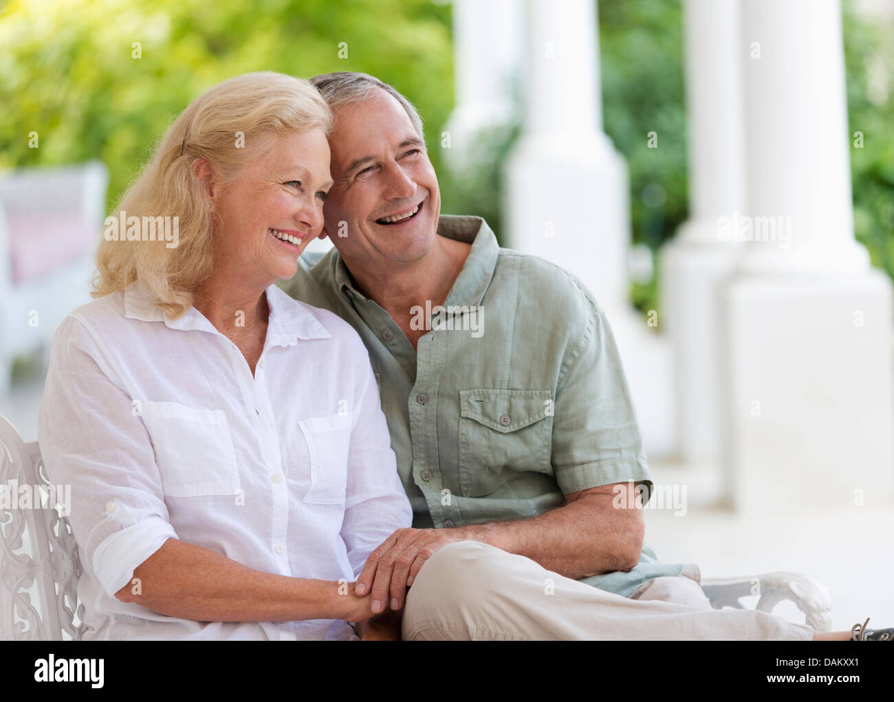 Older couple hugging on porch Stock Photo