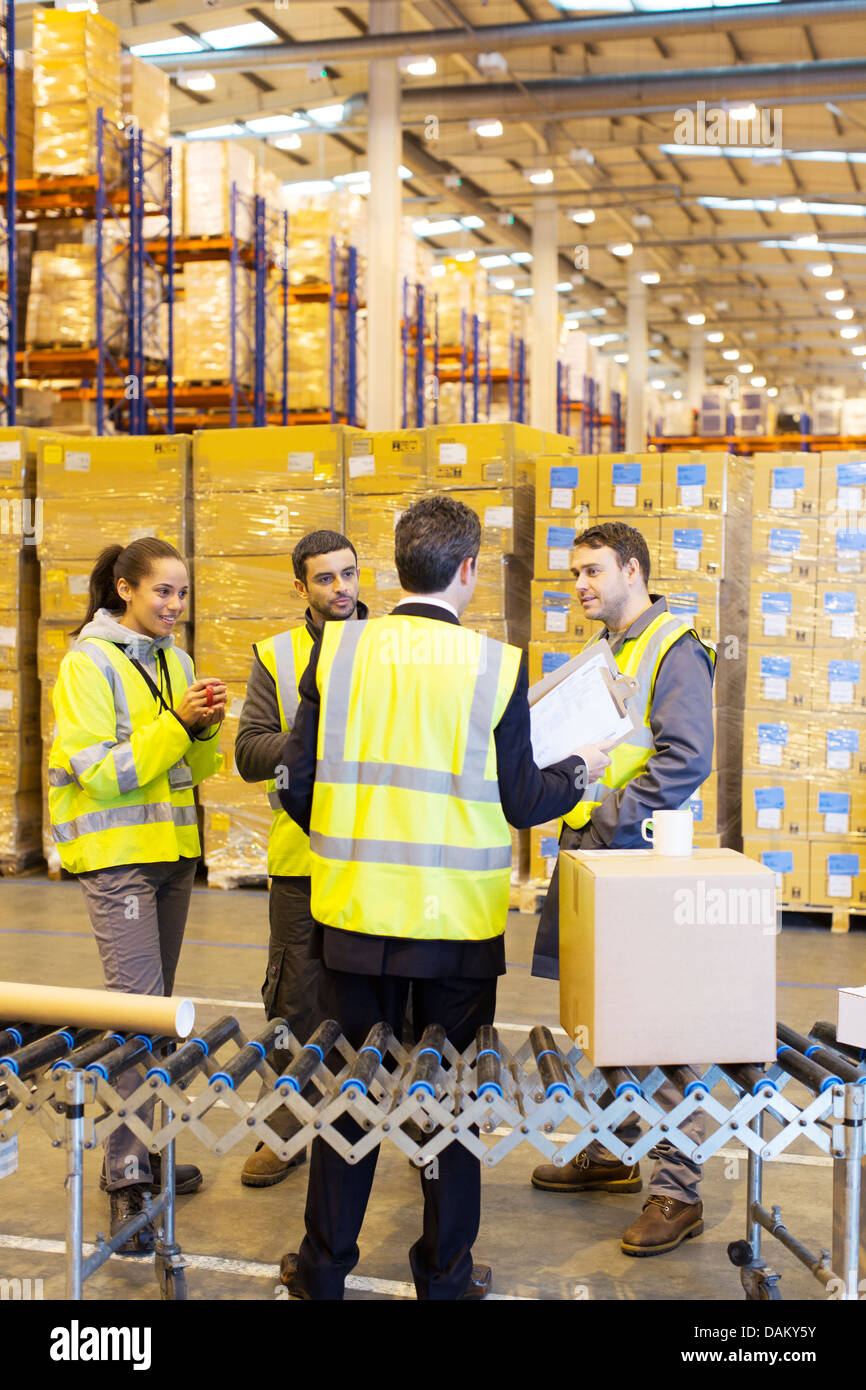 Businessman and workers talking in warehouse Stock Photo - Alamy
