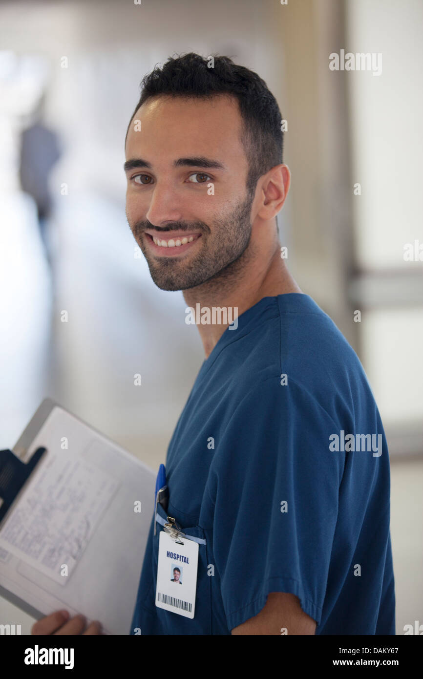 Nurse smiling in hospital hallway Stock Photo