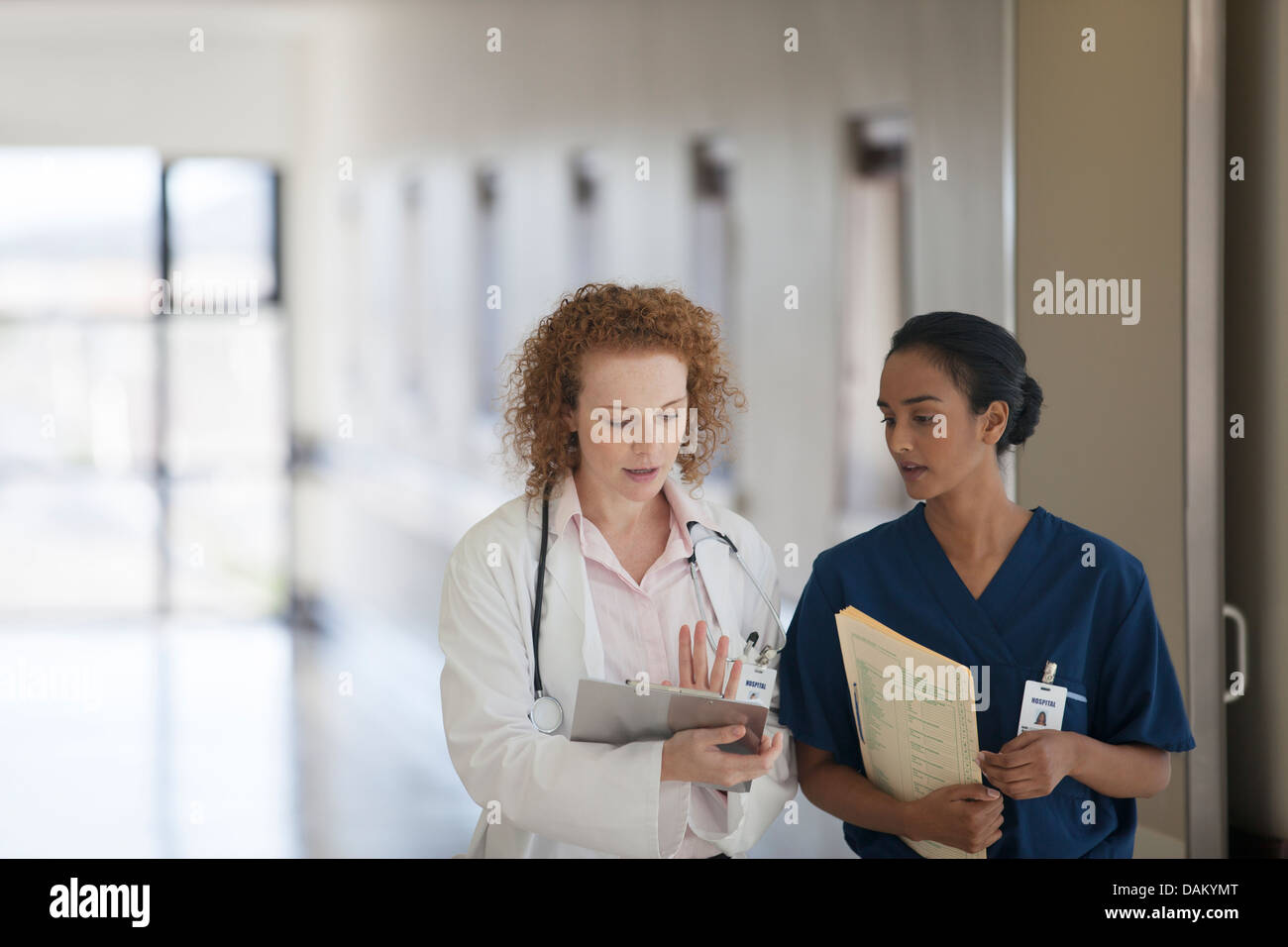 Doctor and nurse talking in hospital hallway Stock Photo - Alamy