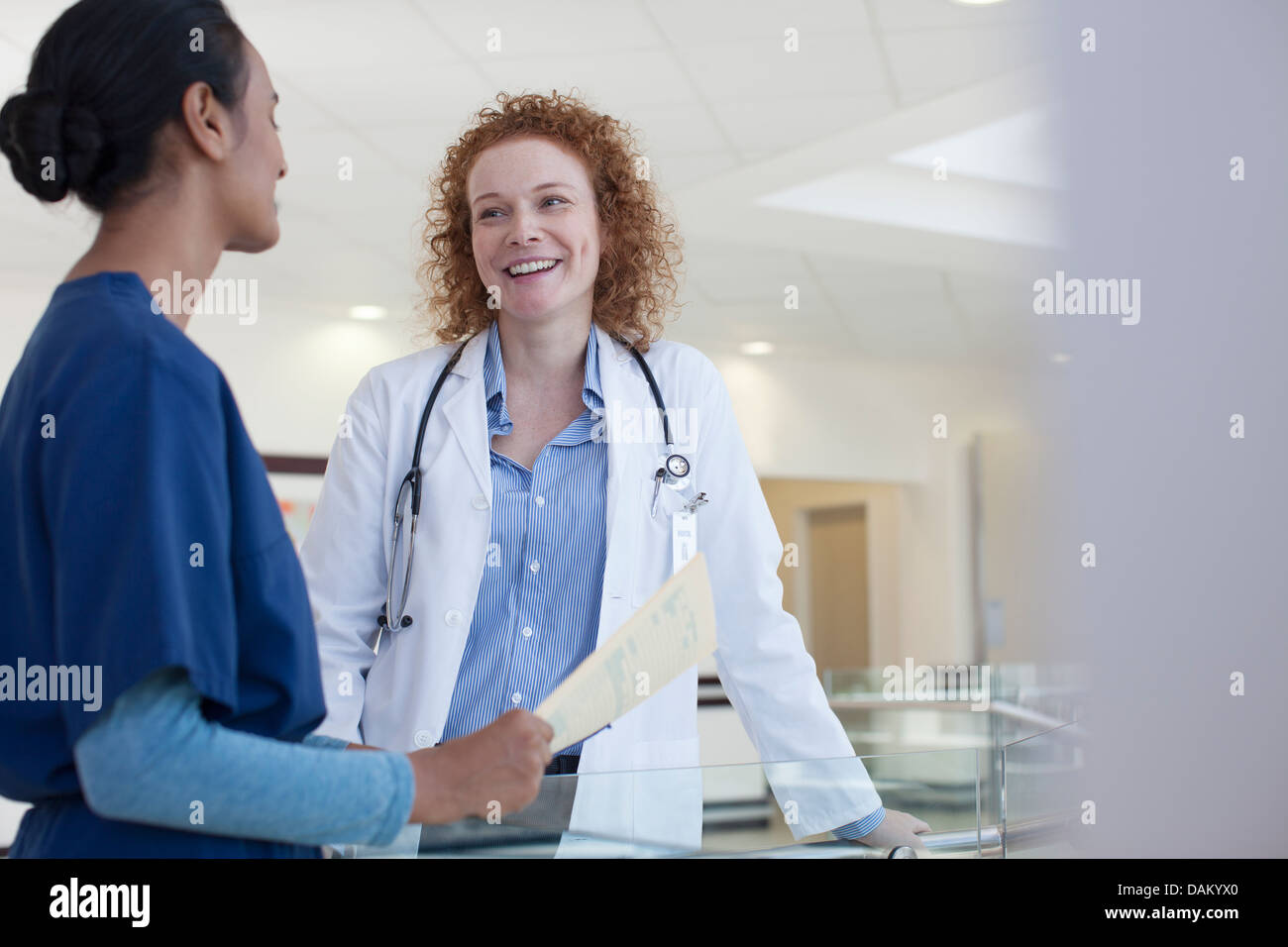 Doctor and nurse talking in hospital hallway Stock Photo