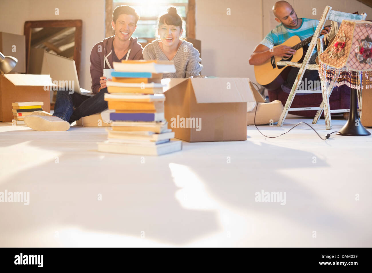 Friends relaxing together in new attic Stock Photo