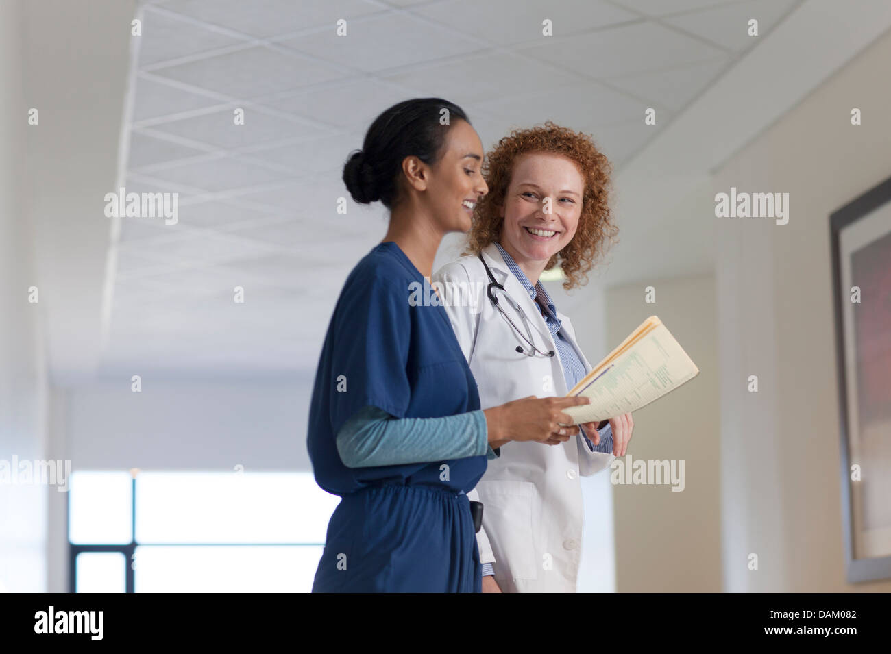 Doctor and nurse talking in hospital hallway Stock Photo