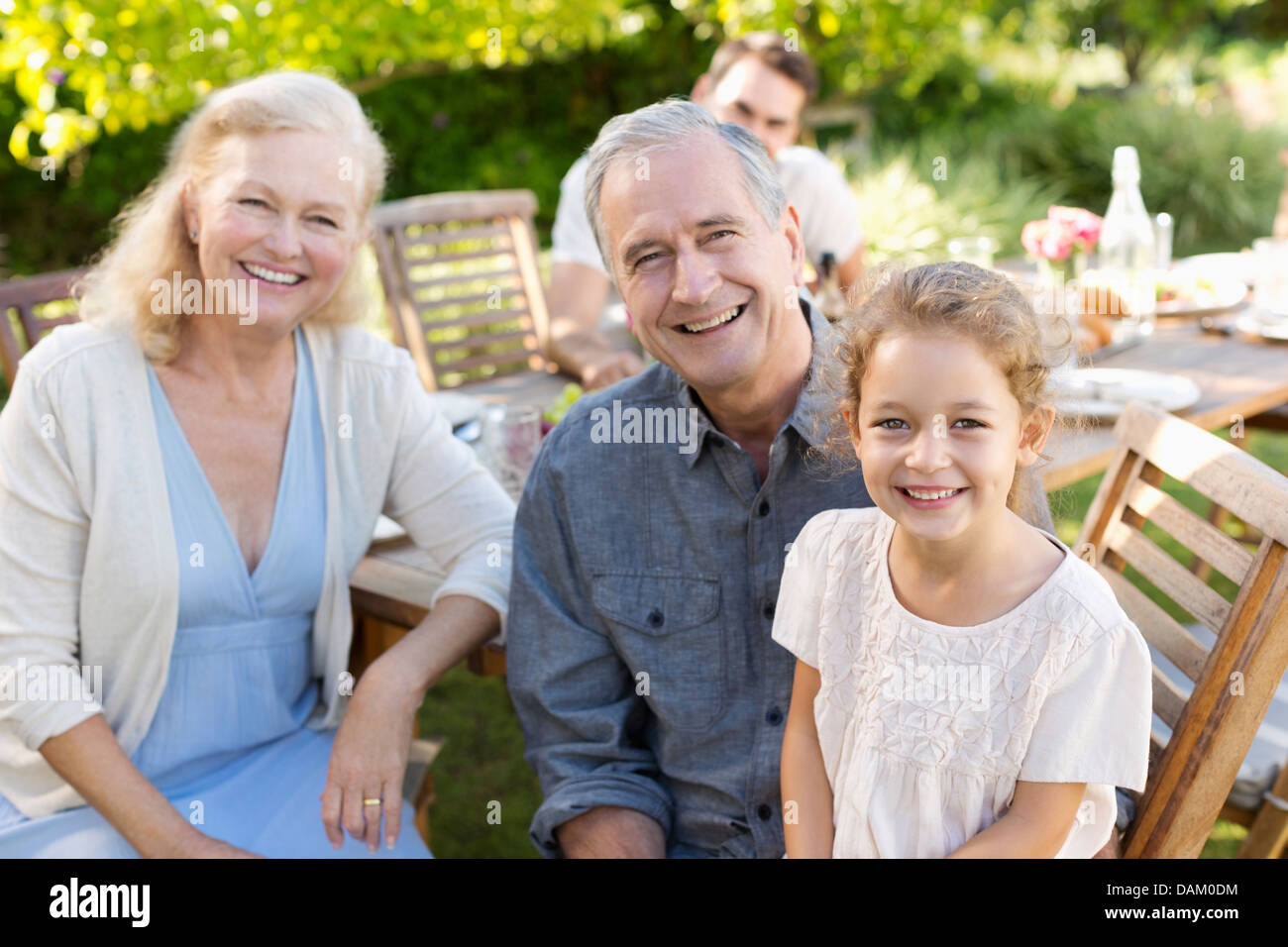 Older couple and granddaughter smiling outdoors Stock Photo