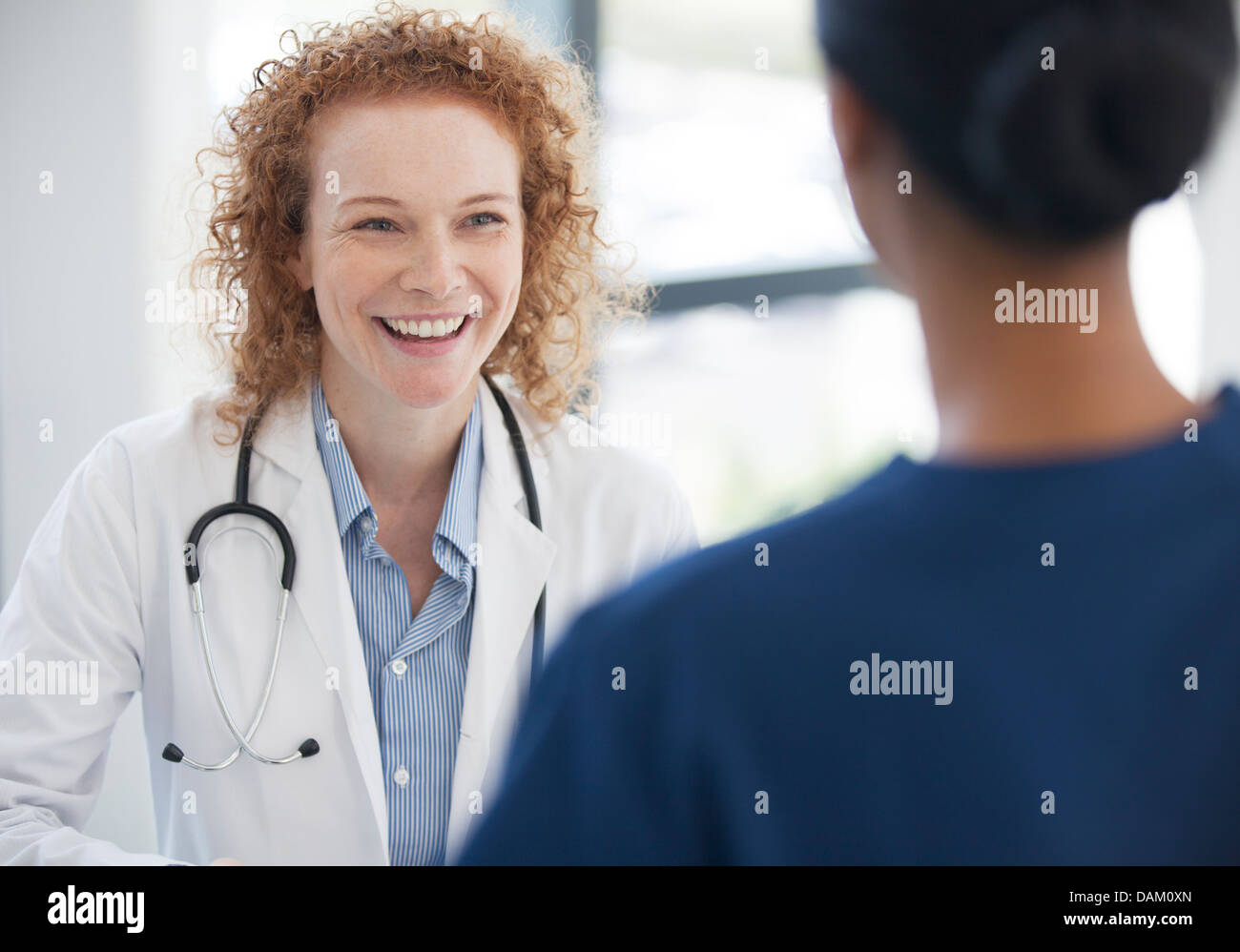 Doctor and nurse talking in hospital hallway Stock Photo