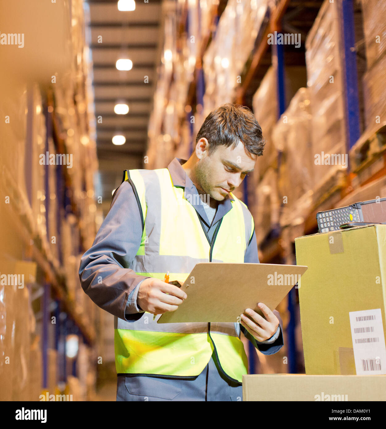 Worker reading clipboard in warehouse Stock Photo Alamy