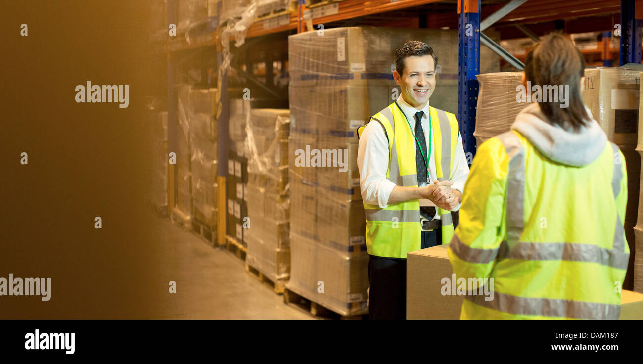 Workers talking in warehouse Stock Photo - Alamy