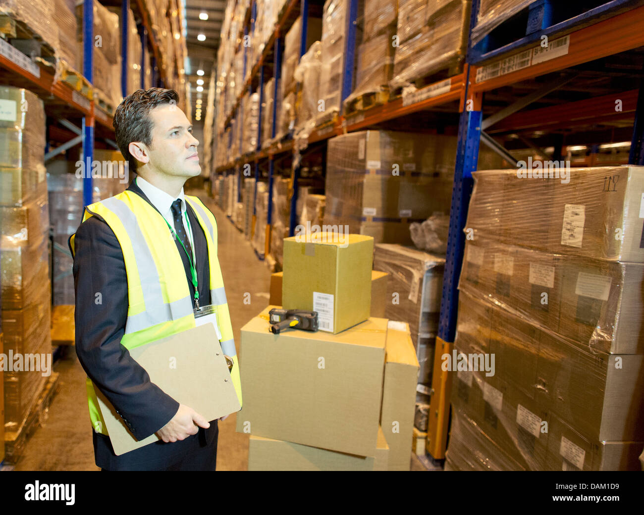 Businessman holding clipboard in warehouse Stock Photo