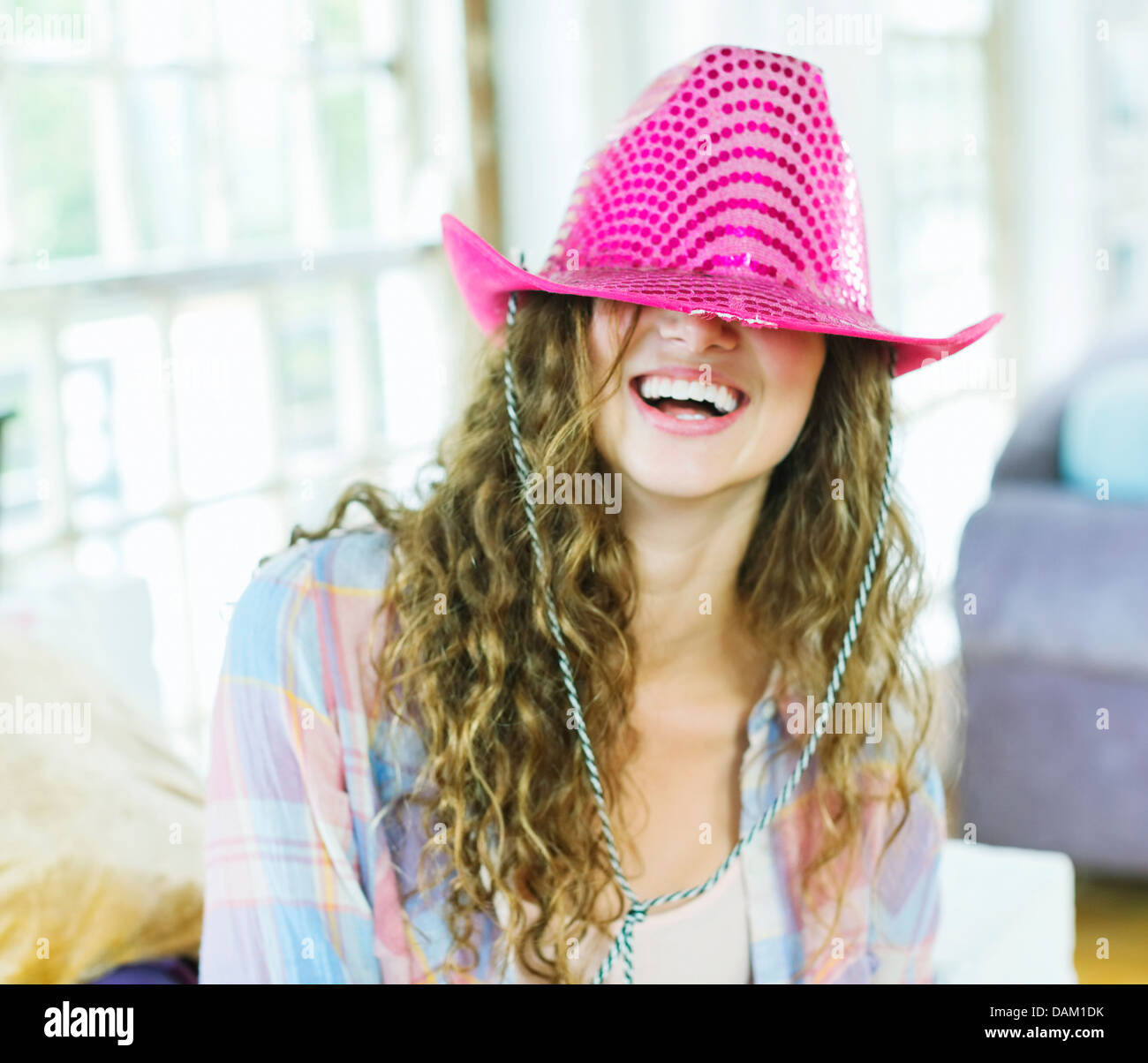 Woman wearing cowboy hat over her eyes Stock Photo