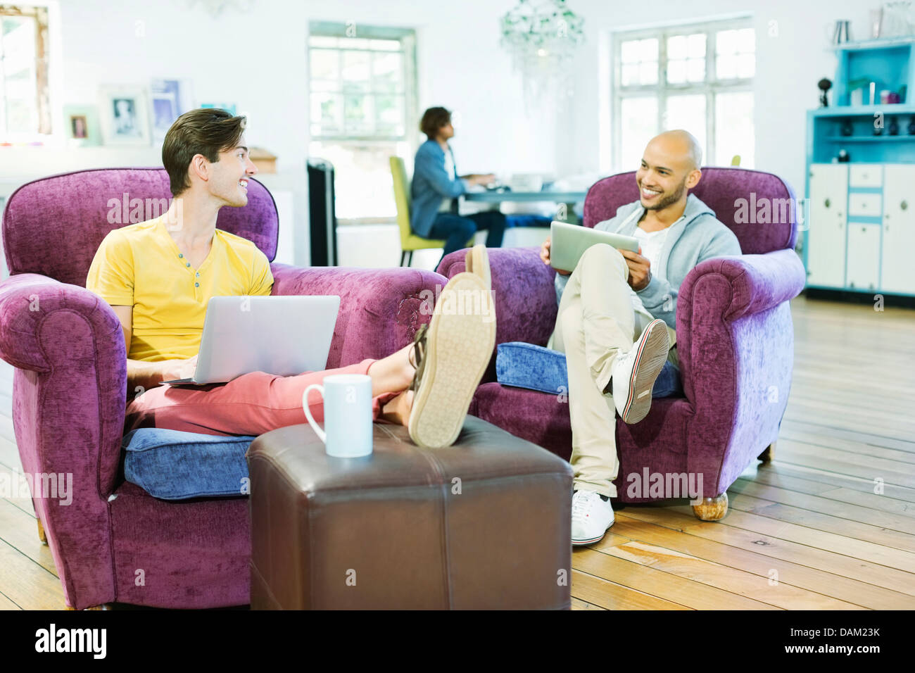 Men relaxing together in living room Stock Photo
