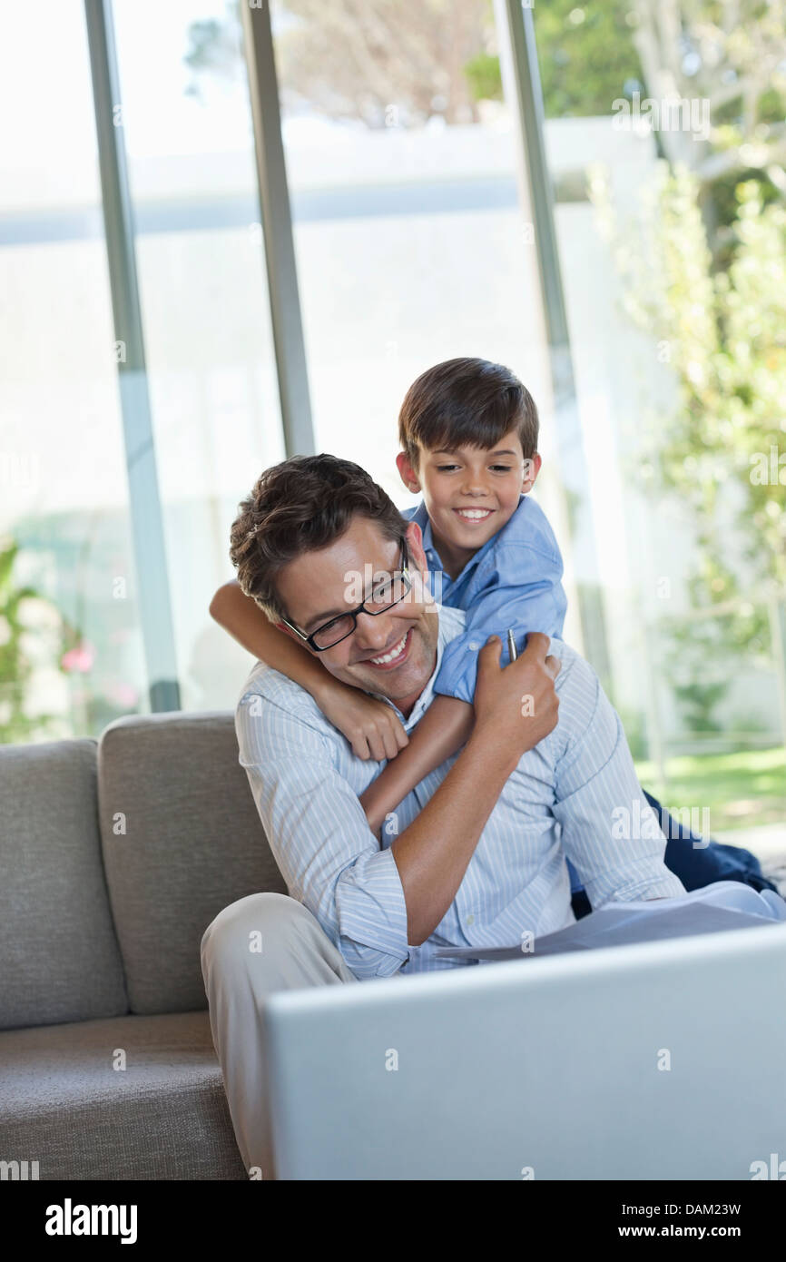 Father and son using laptop on sofa Stock Photo