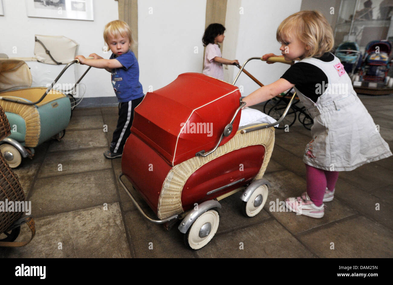 Several two-year-olds from the daycare centre 'Children's dreams' play with doll buggies at the German Stroller Museum in Zeitz, Germany, 11 May 2011. The museum contains around 550 stroller and is the largest of its klind in Germany. Strollers from 1860 till now can be seen. Photo: Waltraud Grubitzsch Stock Photo