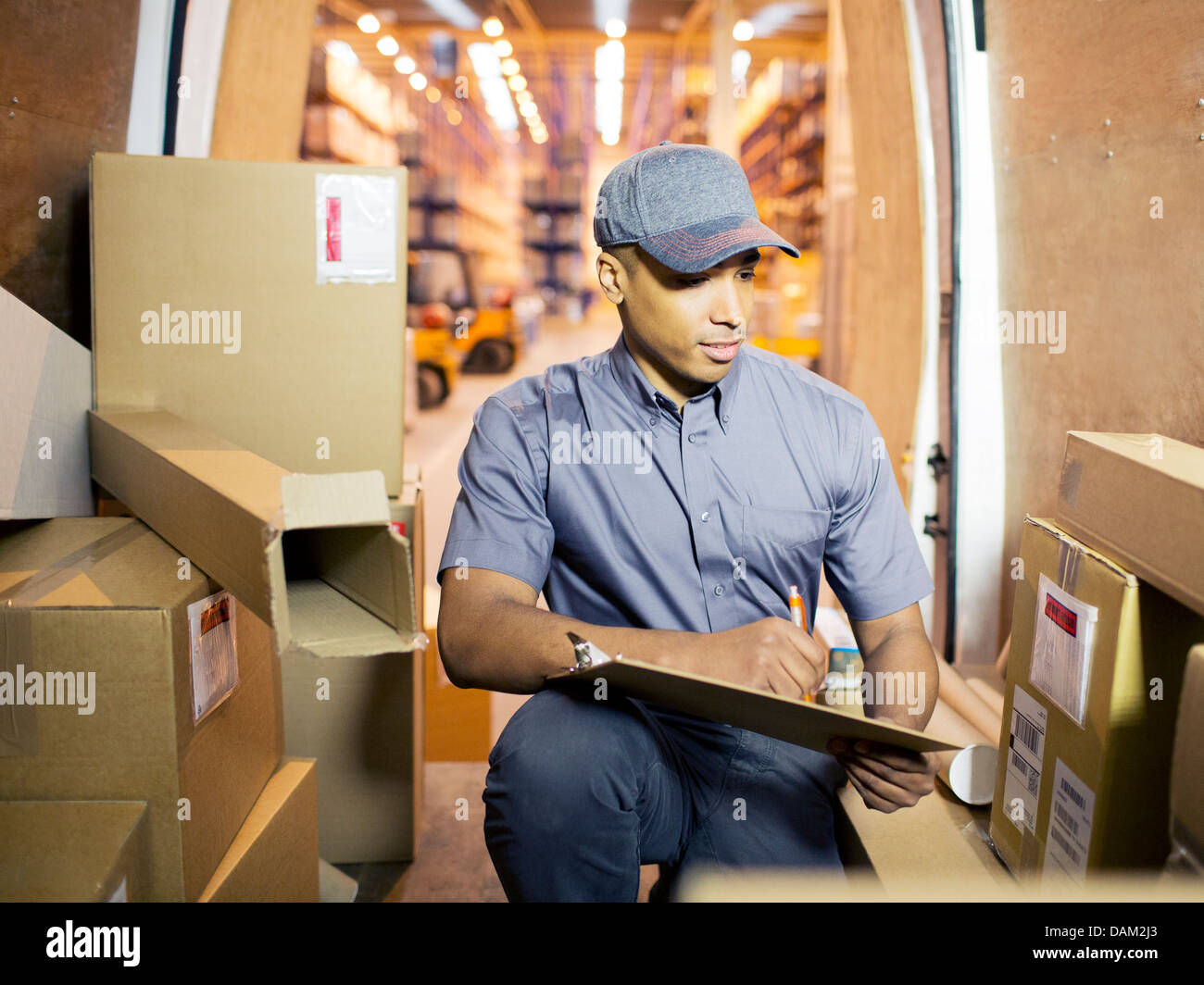 Delivery boy checking boxes in van Stock Photo