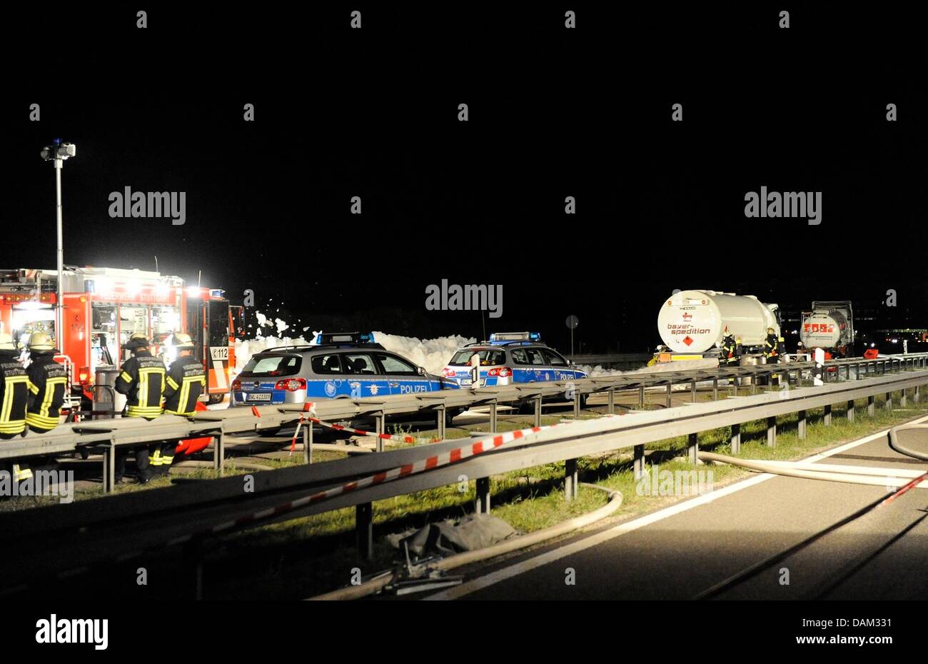 Fire fighters stand near a scene of an accident where two lorries carrying hazardous goods were involved at the A8 motorway near Stuttgart, Germany, 18 May 2011. Acetic acid and petrol leaked onto the street and caused a full closure of the motorway. Photo: Oskar Eyb Stock Photo