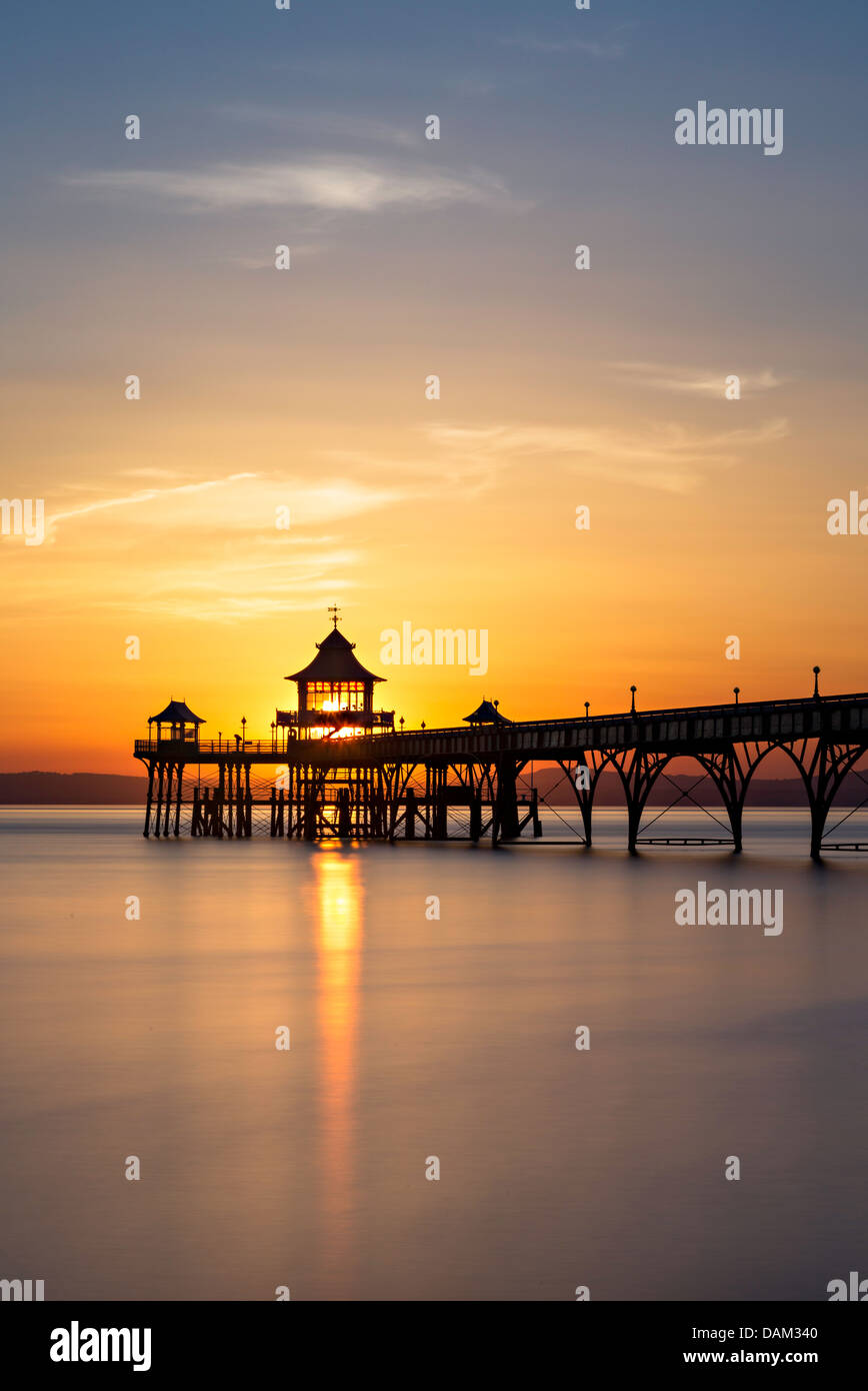 Clevedon Pier at sunset. The sun sets directly behind the pavilion at the end of Clevedon Pier and the sky turns vibrant colours Stock Photo