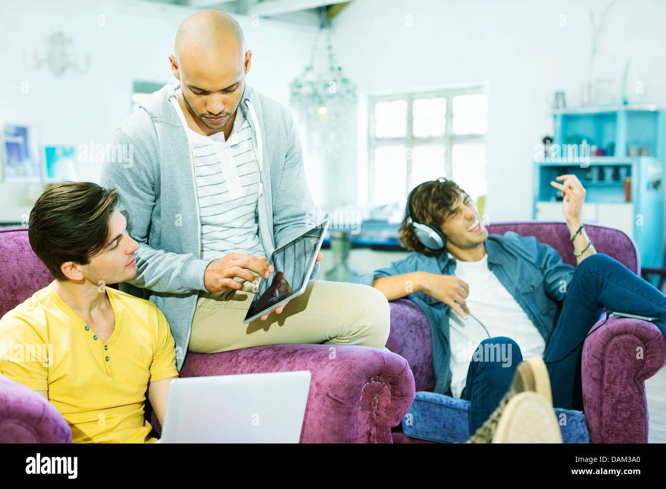 Men relaxing together in living room Stock Photo