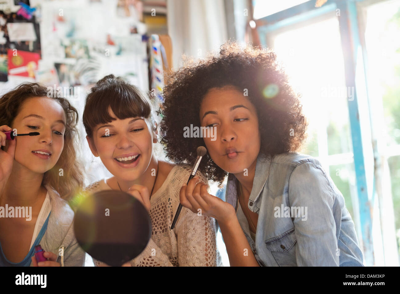 Women applying makeup in bedroom Stock Photo